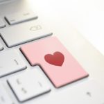 Touche de clavier d'ordinateur personnalisée avec un autocollant rose et un cœur rouge.