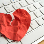Cœur en papier froissé sur un clavier d'ordinateur.