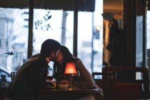 Couple s'embrassant dans un café intimiste.