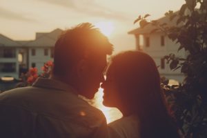 Silhouettes d'un couple se faisant face au coucher du soleil.